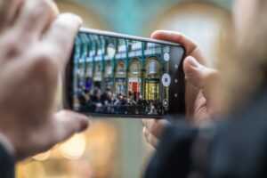 a smartphone is held in front of a busy building to take a picture